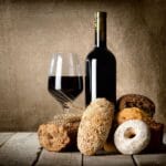 DIfferent types of bread, glass and bottle of wine on wooden table