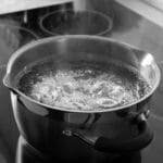 Boiling hot water in black pot