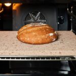 Loaf of bread on baking stone in oven