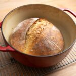 Loaf of bread in dutch oven on baking grid