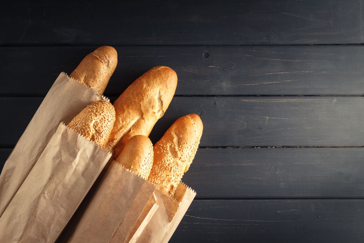 Baguettes in paper bags on black table