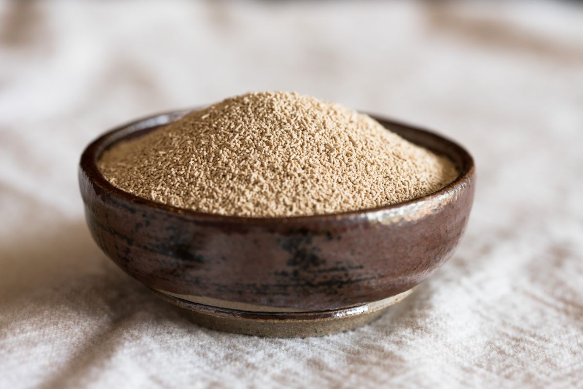 Bowl of dry yeast on white  cloth table