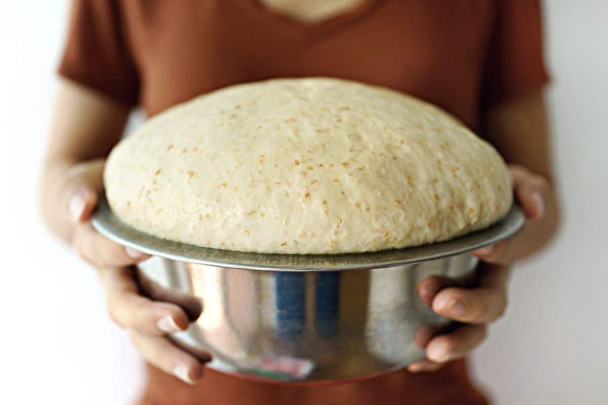 Woman holding bowl of rising bread dough
