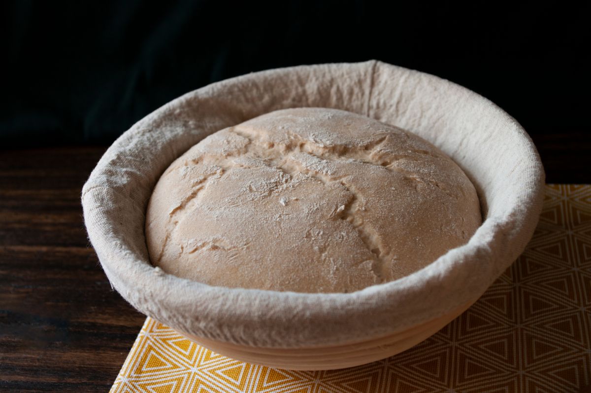 Resting bread dough in proofing basket on table