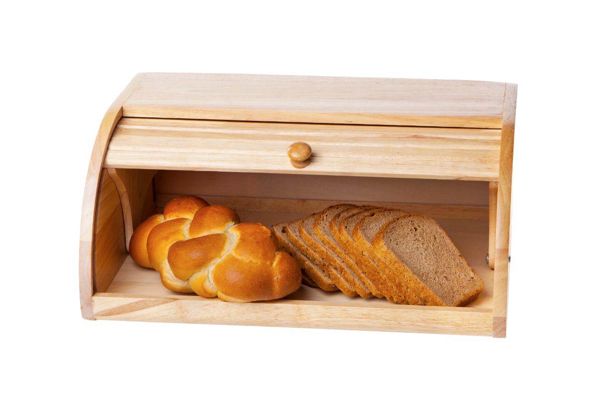 Loaf of bread and slices of bread in wooden bread box
