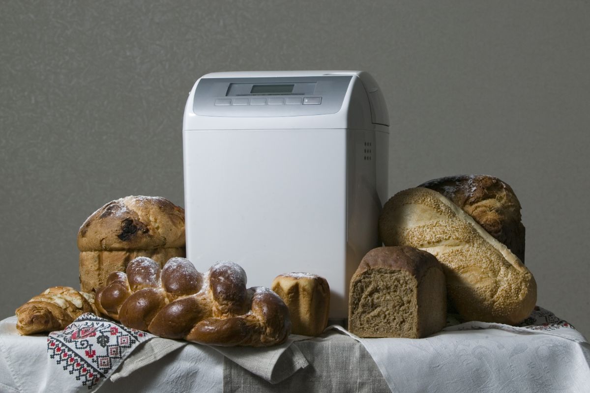 Breadmaker with varietes of bread on white table cloth
