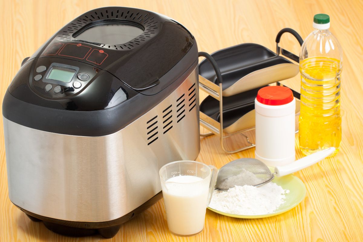 Bread maker with ingredients around on table