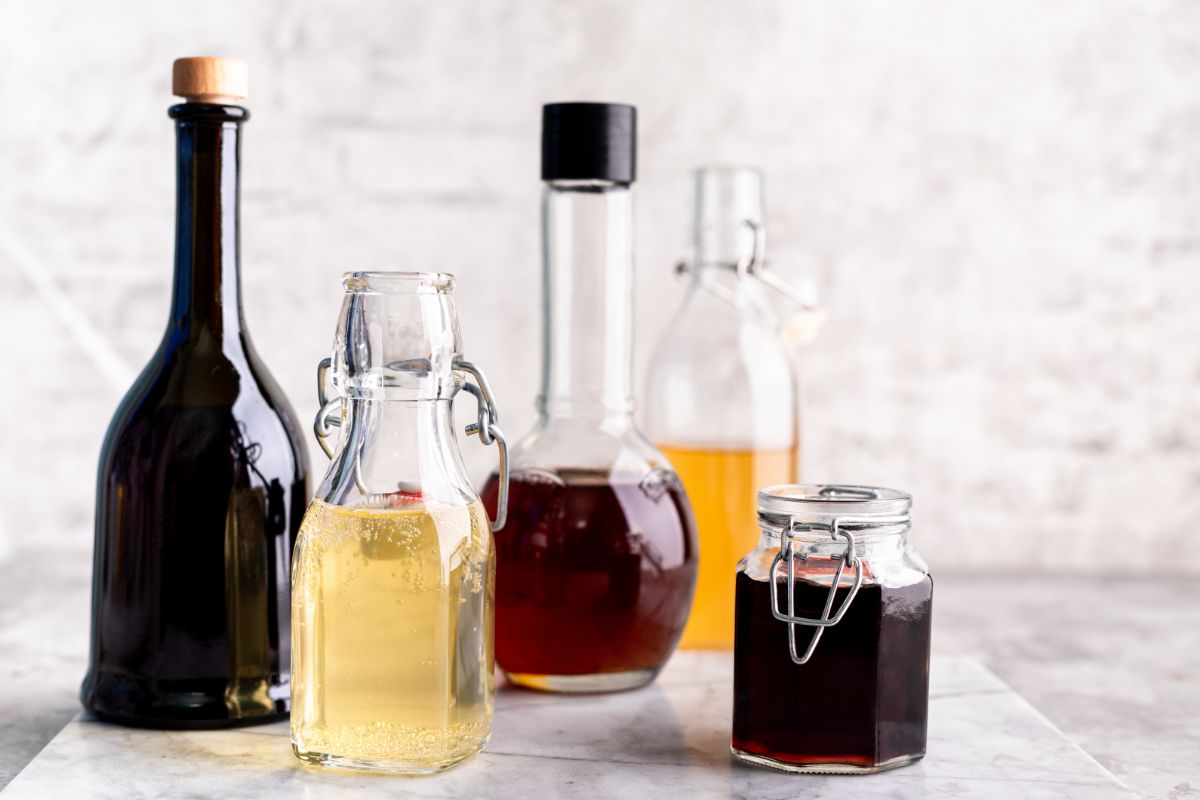 Different types of vinegar in glass bottles and jar