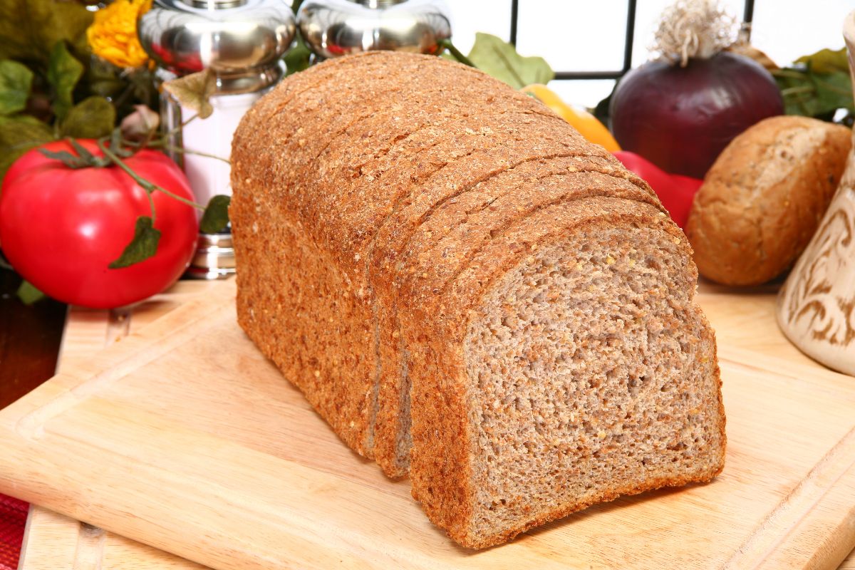 Sliced loaf of ezekiel bread on wooden pad