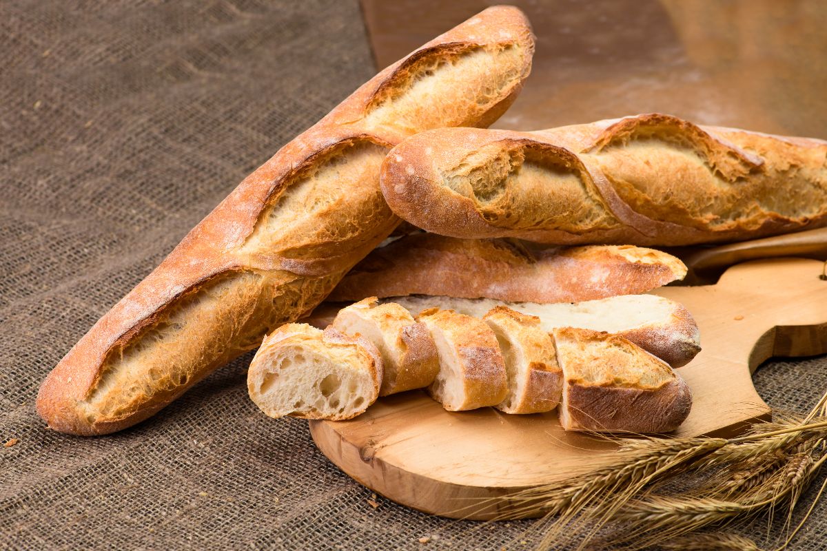 French baguettes on wooden pad partialy sliced