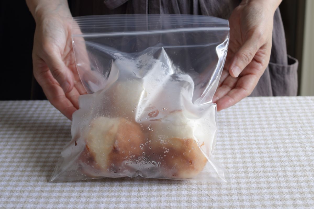Hands touch bag full of frozen bread on table