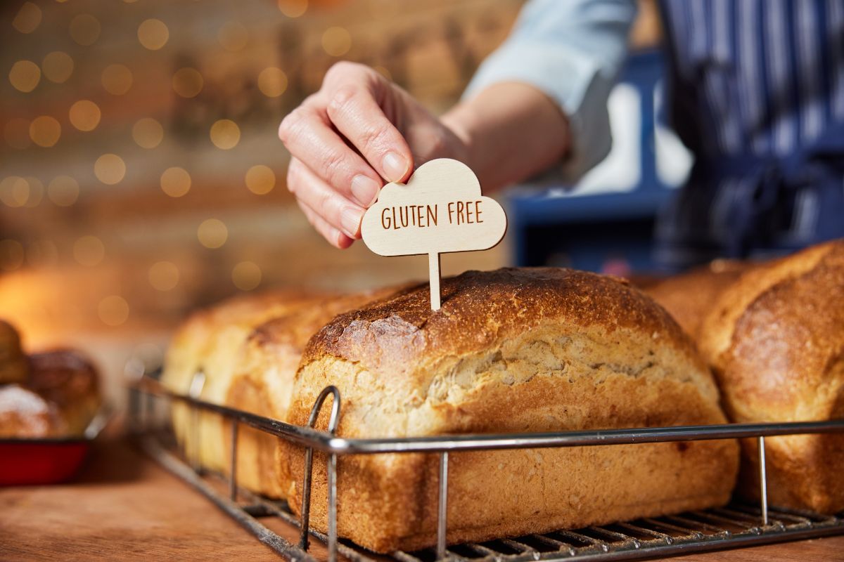 Loaves of bread with small sign held by hand