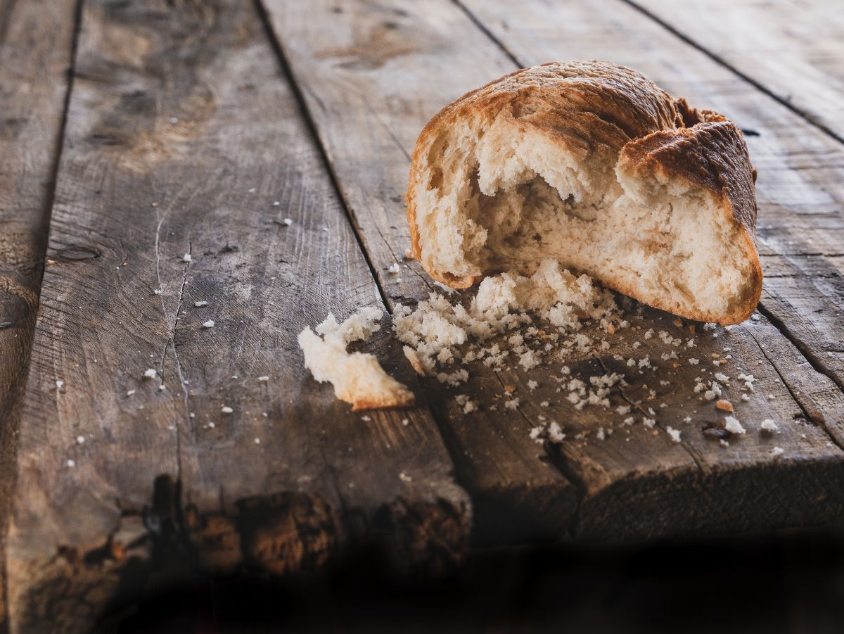 Old and partially eaten loaf of bread on wooden table