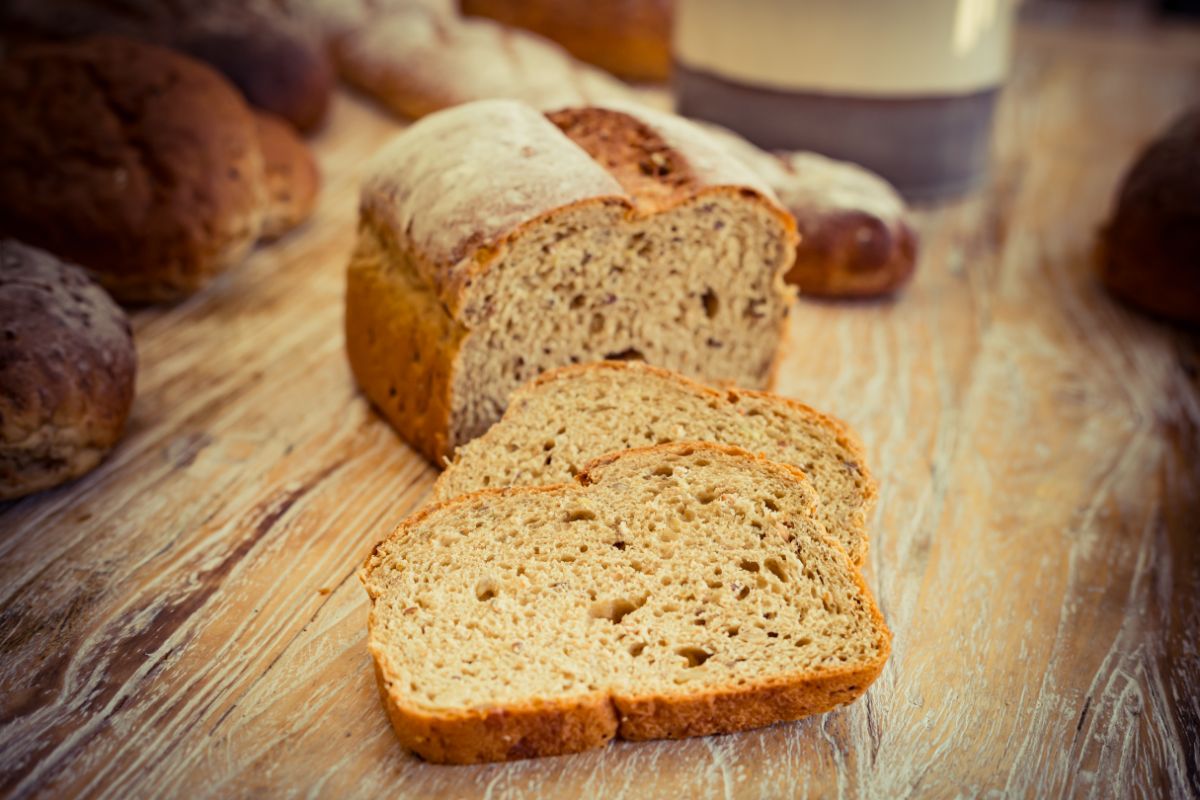 Partialy sliced loaf of ezekiel bread on wooden table