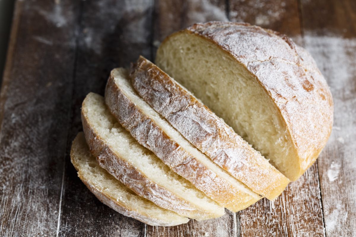 Loaf of bread partialy sliced on wooden table